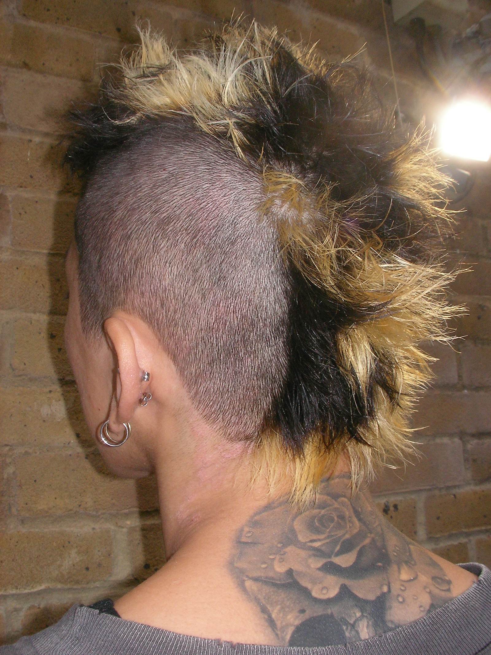 Close-up of tri-tone section colour (black, gold, platinum) on a men's Mohawk.