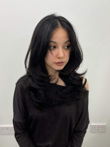 Back view of a brunette Butterfly Haircut with voluminous "winged" layers and a bouncy blowout at Assort London.