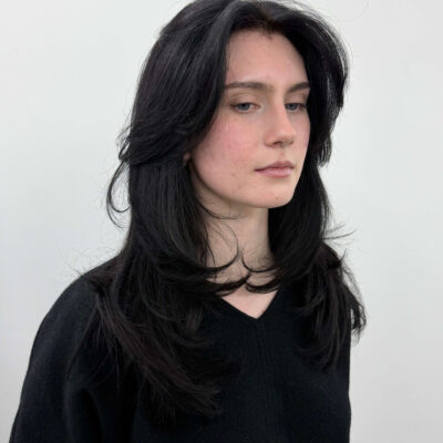 Close-up of face-framing Butterfly layers on dark hair, showing 2026 hair trends and texture.