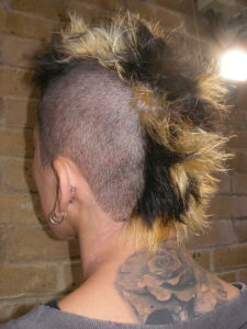 Close-up of tri-tone section colour (black, gold, platinum) on a men's Mohawk.
