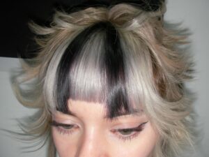 A triple-process creative color with bold fung bangs, inspired by anime aesthetic and protected by K18 treatment.